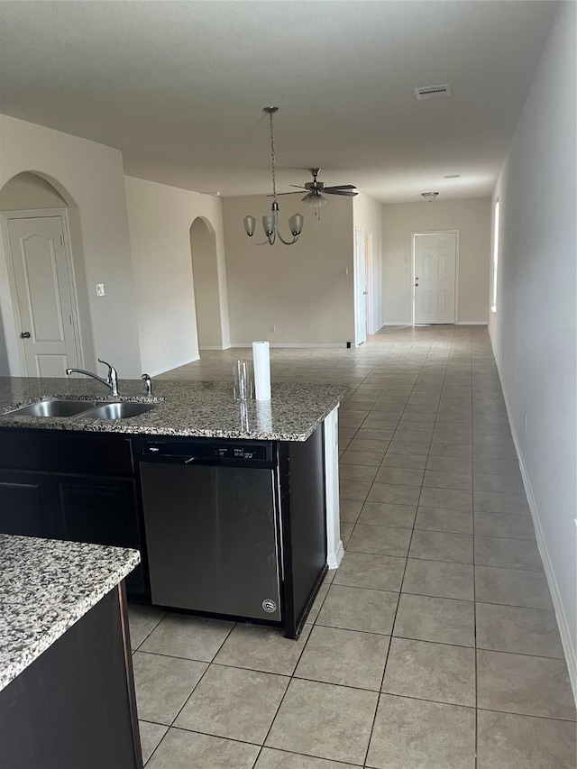 2135 Republic Way, Missouri City, TX 77489 - kitchen featuring stainless steel dishwasher, dark cabinetry, arched walkways, and light tile patterned flooring