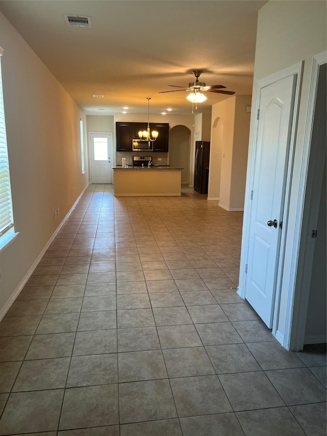 2135 Republic Way, Missouri City, TX 77489 - unfurnished living room with tile patterned flooring, arched walkways, ceiling fan, and a chandelier