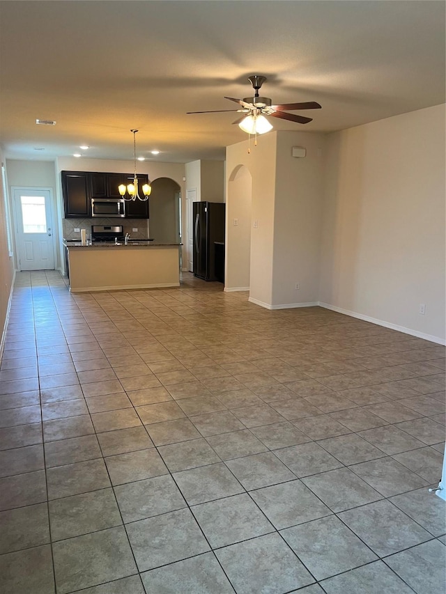 2135 Republic Way, Missouri City, TX 77489 - unfurnished living room with arched walkways, light tile patterned floors, a ceiling fan, and a chandelier