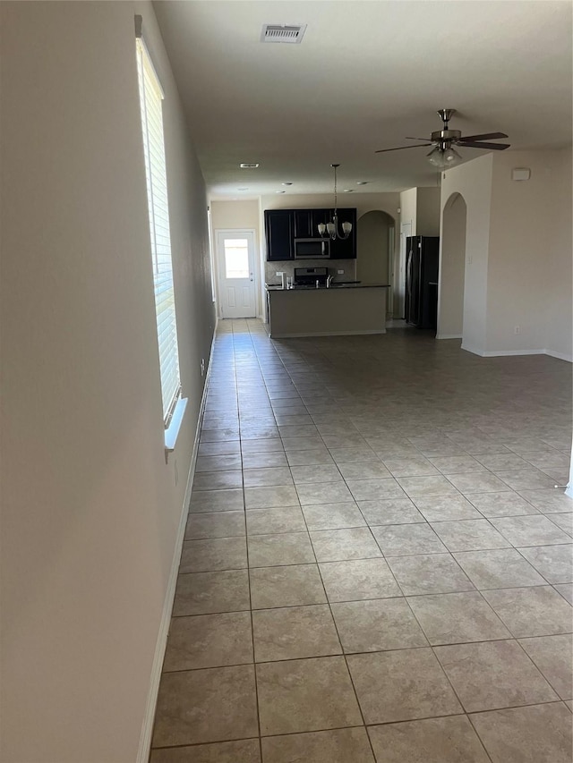 2135 Republic Way, Missouri City, TX 77489 - unfurnished living room with arched walkways, light tile patterned floors, and a ceiling fan