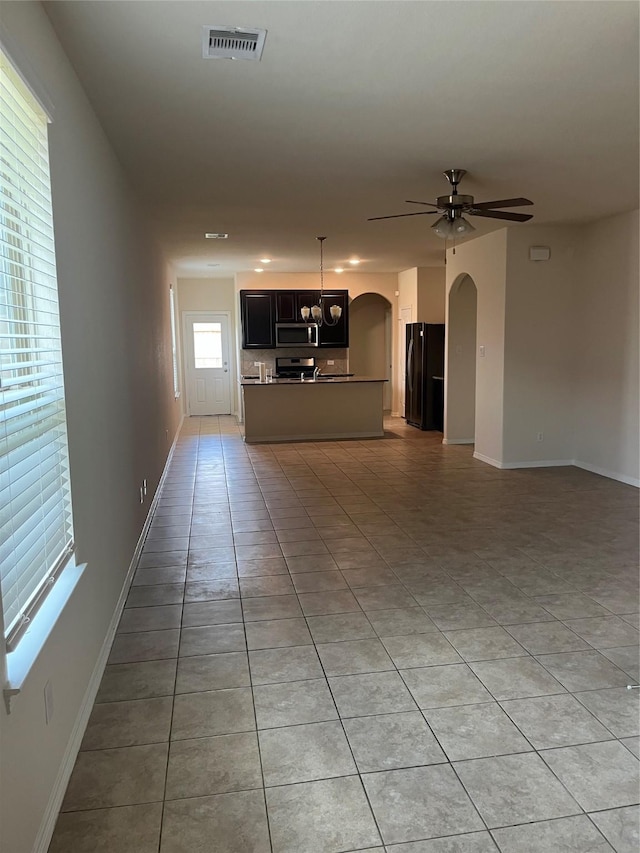 2135 Republic Way, Missouri City, TX 77489 - unfurnished living room featuring light tile patterned floors, arched walkways, and ceiling fan