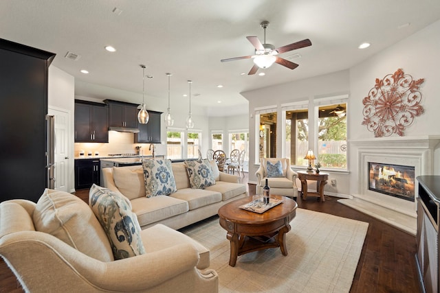 3426 Satton Ranch Ln, Fulshear, TX 77441 - living area with a ceiling fan, recessed lighting, healthy amount of natural light, a glass covered fireplace, and dark wood-type flooring
