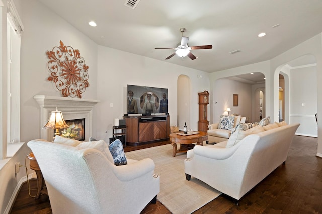 3426 Satton Ranch Ln, Fulshear, TX 77441 - living room featuring arched walkways, a ceiling fan, dark wood-style floors, recessed lighting, and a lit fireplace