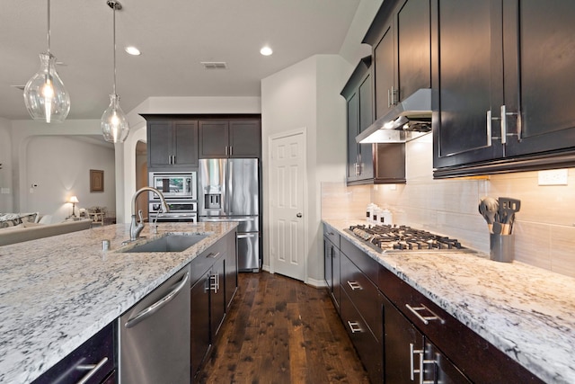 3426 Satton Ranch Ln, Fulshear, TX 77441 - kitchen with appliances with stainless steel finishes, under cabinet range hood, light stone counters, tasteful backsplash, and recessed lighting