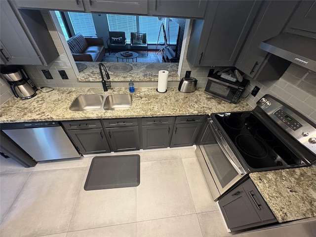 3244 Poe Dr, Montgomery, TX 77356 - kitchen featuring stainless steel appliances, light stone countertops, backsplash, and light tile patterned floors