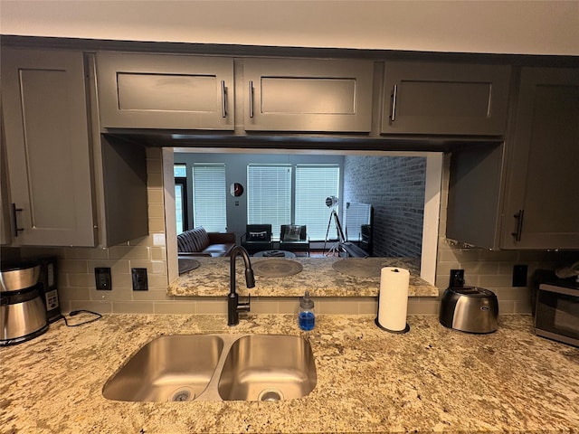 3244 Poe Dr, Montgomery, TX 77356 - kitchen with backsplash, stainless steel microwave, and light stone countertops