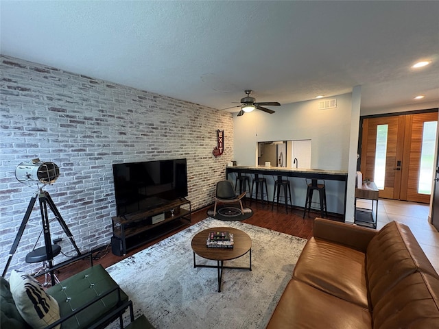 3244 Poe Dr, Montgomery, TX 77356 - living room with ceiling fan, recessed lighting, wood finished floors, and brick wall