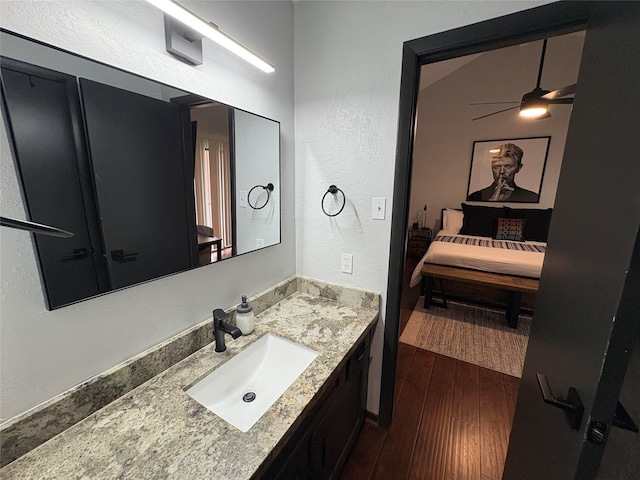 3244 Poe Dr, Montgomery, TX 77356 - bathroom with vanity, wood finished floors, a textured wall, a ceiling fan, and connected bathroom