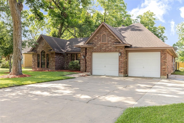 214 Balsam St, Lake Jackson, TX 77566 - view of front facade with brick siding, an attached garage, concrete driveway, a front lawn, and roof with shingles