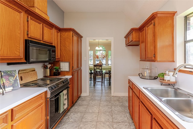 214 Balsam St, Lake Jackson, TX 77566 - kitchen featuring electric range, black microwave, light countertops, brown cabinetry, and lofted ceiling