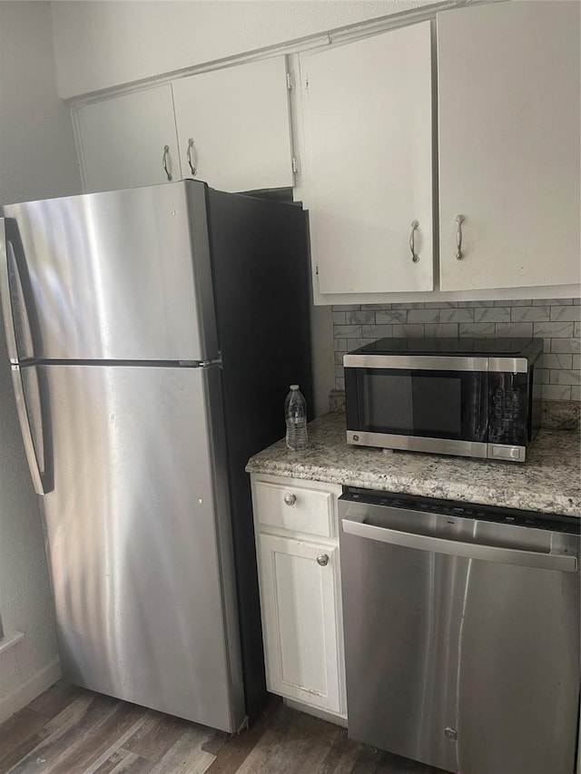 5625 Antoine Dr Unit 1011, Houston, TX 77091 - kitchen featuring appliances with stainless steel finishes, dark wood-style flooring, tasteful backsplash, white cabinets, and light stone countertops