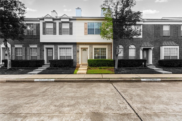 2930 Grants Lake Blvd Unit 2404, Sugar Land, TX 77479 - view of front of house featuring entry steps, brick siding, a chimney, and uncovered parking