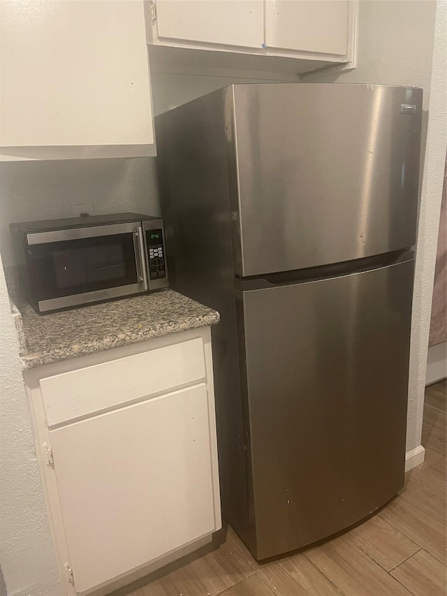 5625 Antoine Dr Unit 1405, Houston, TX 77091 - kitchen with stainless steel appliances, light wood-type flooring, and white cabinets