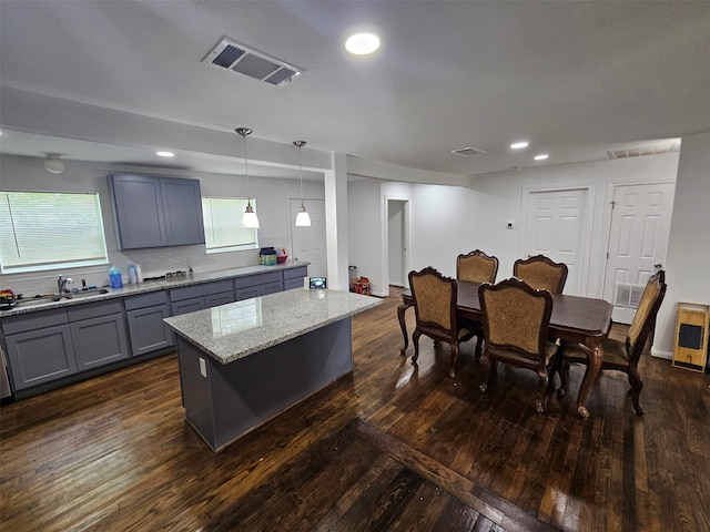 907 Whitaker Ave, Pasadena, TX 77506 - kitchen featuring gray cabinets, a kitchen island, light stone counters, dark wood finished floors, and recessed lighting