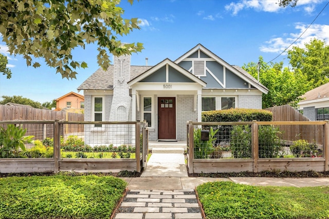 5001 Farmer St, Houston, TX 77020 - view of front facade featuring brick siding, a vegetable garden, a chimney, and roof with shingles