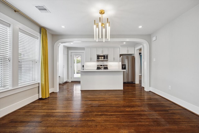 5001 Farmer St, Houston, TX 77020 - kitchen with appliances with stainless steel finishes, arched walkways, recessed lighting, white cabinetry, and dark wood-style floors
