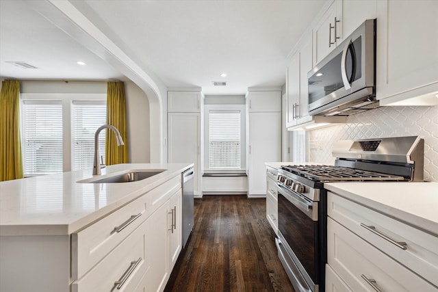 5001 Farmer St, Houston, TX 77020 - kitchen with stainless steel appliances, backsplash, light countertops, dark wood-style flooring, and white cabinetry