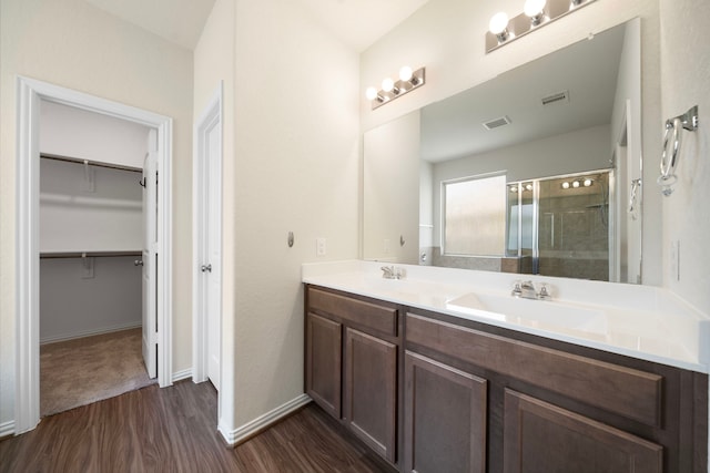 6406 Shadowbrook Hollow Trl, Katy, TX 77493 - full bathroom with wood finished floors, a shower stall, double vanity, and a walk in closet