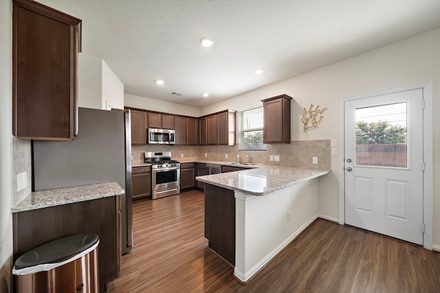 6406 Shadowbrook Hollow Trl, Katy, TX 77493 - kitchen with stainless steel appliances, dark wood-style floors, a peninsula, backsplash, and recessed lighting