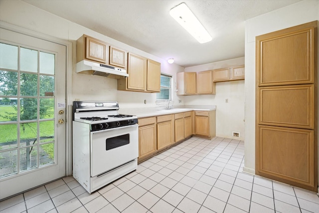 8510 Montridge Dr, Houston, TX 77055 - kitchen with white range with gas cooktop, under cabinet range hood, light brown cabinetry, light countertops, and light tile patterned floors