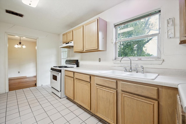 8510 Montridge Dr, Houston, TX 77055 - kitchen featuring white range with gas stovetop, under cabinet range hood, light brown cabinetry, light tile patterned floors, and light countertops