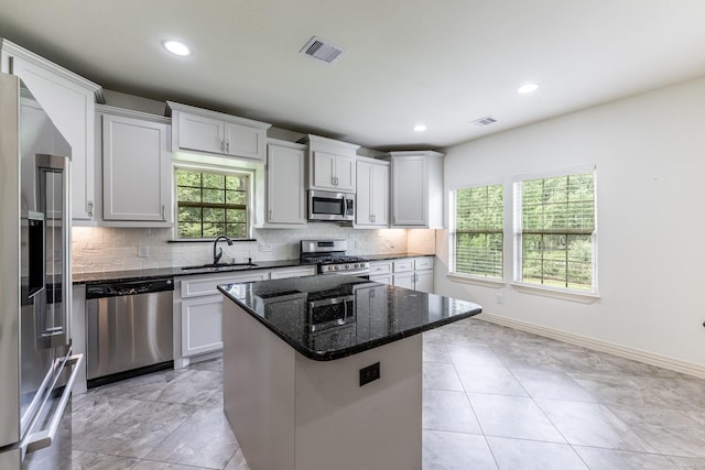 104 Drexal Dr, Huntsville, TX 77340 - kitchen with appliances with stainless steel finishes, decorative backsplash, a center island, dark stone countertops, and recessed lighting