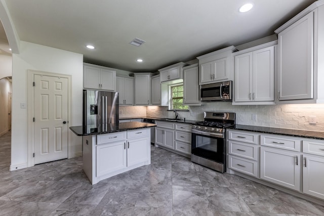 104 Drexal Dr, Huntsville, TX 77340 - kitchen featuring stainless steel appliances, dark stone counters, backsplash, a center island, and recessed lighting