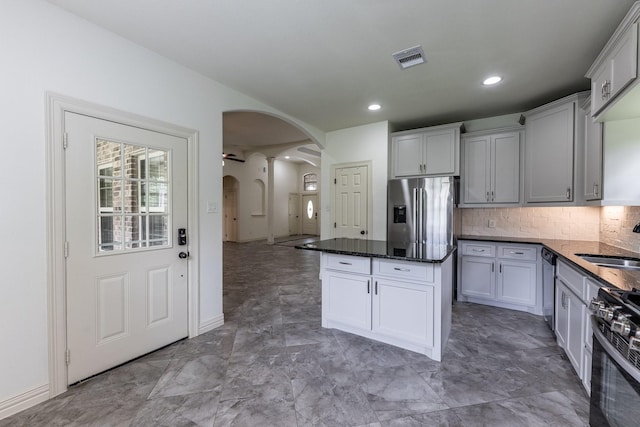 104 Drexal Dr, Huntsville, TX 77340 - kitchen with arched walkways, stainless steel appliances, a center island, tasteful backsplash, and recessed lighting
