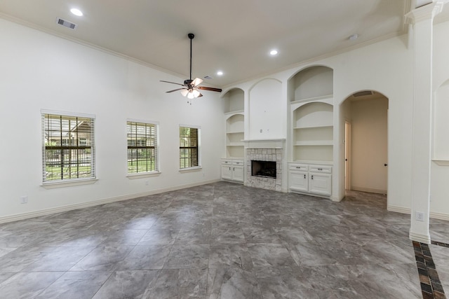 104 Drexal Dr, Huntsville, TX 77340 - unfurnished living room featuring built in shelves, crown molding, a ceiling fan, a tiled fireplace, and recessed lighting