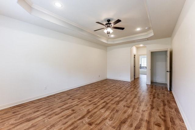 104 Drexal Dr, Huntsville, TX 77340 - unfurnished room with a raised ceiling, arched walkways, crown molding, wood finished floors, and ceiling fan