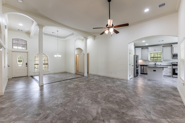 104 Drexal Dr, Huntsville, TX 77340 - unfurnished living room with ornamental molding, ceiling fan, arched walkways, a chandelier, and a high ceiling
