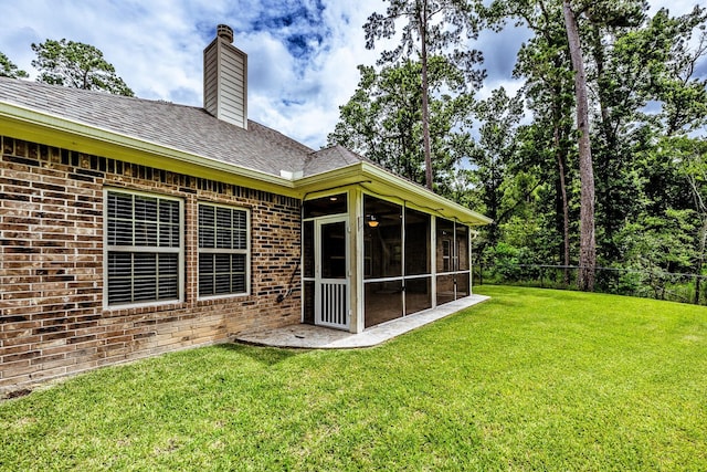 104 Drexal Dr, Huntsville, TX 77340 - rear view of property with a chimney, a sunroom, and brick siding