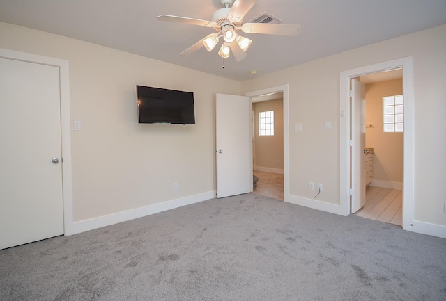 9703 Riddlewood Ln, Houston, TX 77025 - unfurnished bedroom with carpet floors, multiple windows, a ceiling fan, and ensuite bathroom