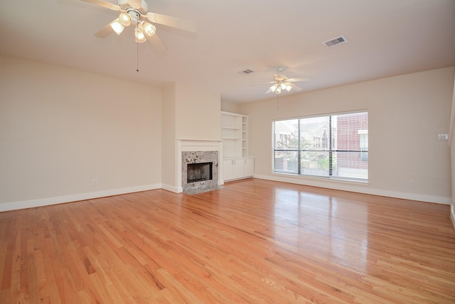 9703 Riddlewood Ln, Houston, TX 77025 - unfurnished living room featuring ceiling fan, light wood finished floors, and a tile fireplace