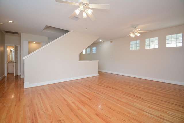 9703 Riddlewood Ln, Houston, TX 77025 - unfurnished living room featuring a ceiling fan, light wood-style flooring, healthy amount of natural light, stairway, and recessed lighting