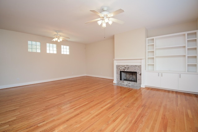 9703 Riddlewood Ln, Houston, TX 77025 - unfurnished living room with ceiling fan, light wood finished floors, and a tiled fireplace