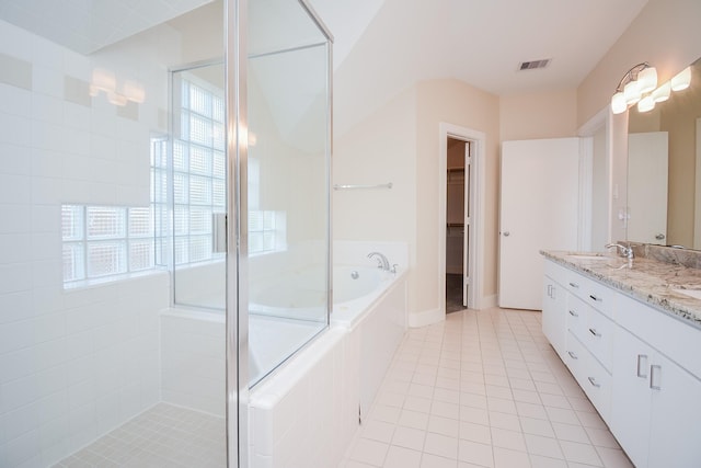 9703 Riddlewood Ln, Houston, TX 77025 - bathroom featuring tiled shower, a bath, double vanity, and tile patterned floors