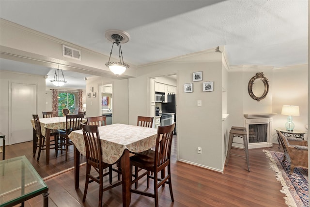 4643 Wild Indigo St Unit 416, Houston, TX 77027 - dining room with crown molding, a fireplace, and dark wood-style flooring