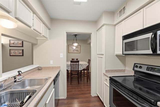 4643 Wild Indigo St Unit 416, Houston, TX 77027 - kitchen with stainless steel appliances, dark wood-type flooring, light countertops, and white cabinetry