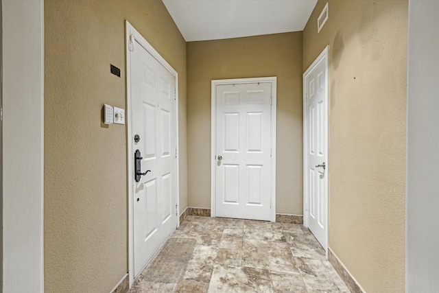 7447 Cambridge St Unit 15, Houston, TX 77054 - doorway to outside featuring a textured wall and light stone finish flooring