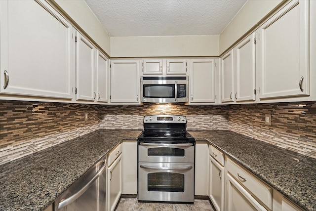 7447 Cambridge St Unit 15, Houston, TX 77054 - kitchen with appliances with stainless steel finishes, a textured ceiling, dark stone countertops, and tasteful backsplash