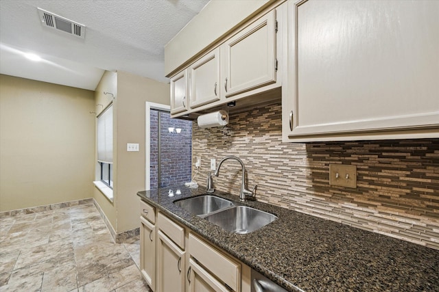7447 Cambridge St Unit 15, Houston, TX 77054 - kitchen with decorative backsplash, dark stone countertops, light stone finish floors, and a textured ceiling
