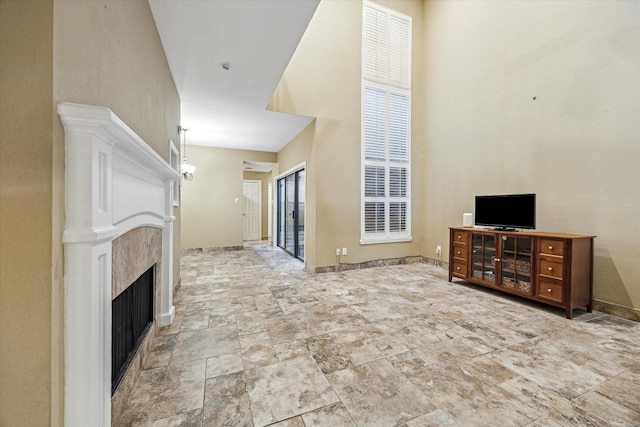 7447 Cambridge St Unit 15, Houston, TX 77054 - unfurnished living room featuring a towering ceiling, stone finish flooring, and a fireplace