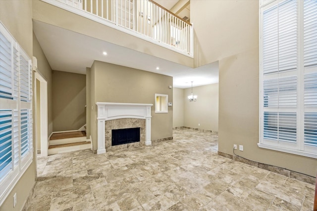 7447 Cambridge St Unit 15, Houston, TX 77054 - unfurnished living room featuring a fireplace, a towering ceiling, a chandelier, and stairway