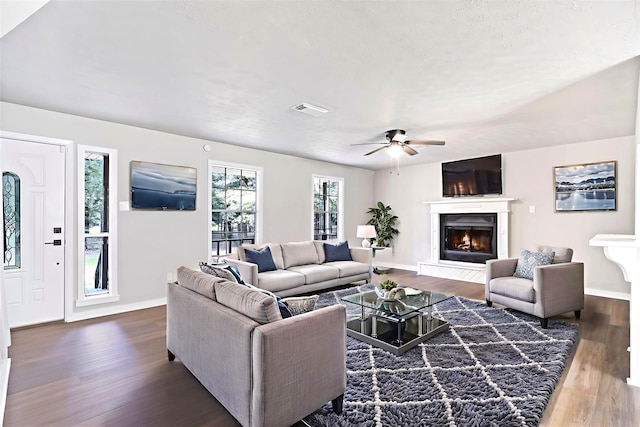 387 Hackberry Dr, Onalaska, TX 77360 - living area with dark wood-type flooring, a glass covered fireplace, and ceiling fan