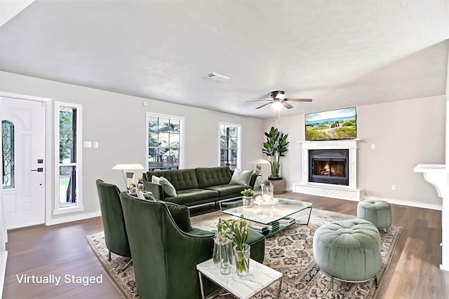 387 Hackberry Dr, Onalaska, TX 77360 - living room featuring dark wood-style flooring, a glass covered fireplace, and a ceiling fan