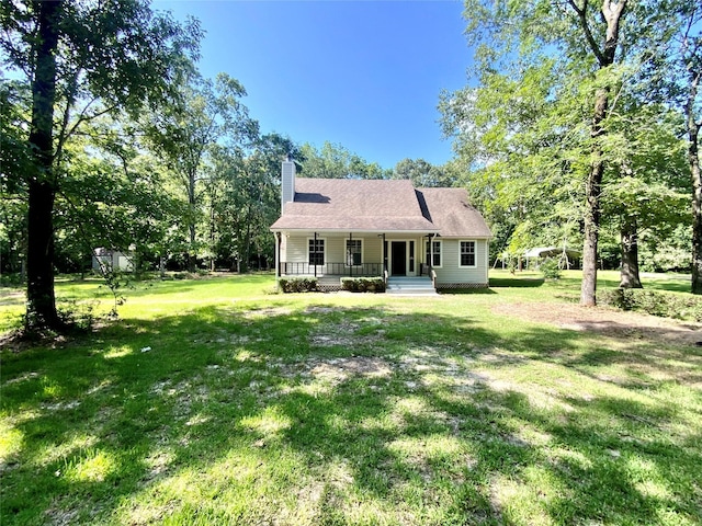 387 Hackberry Dr, Onalaska, TX 77360 - rear view of house with a porch, a chimney, and a lawn