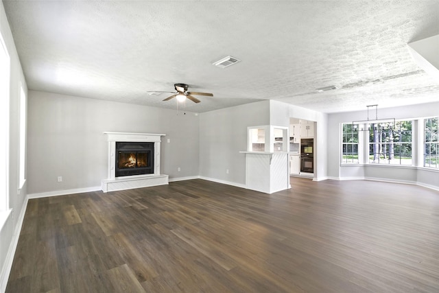 387 Hackberry Dr, Onalaska, TX 77360 - unfurnished living room with a warm lit fireplace, ceiling fan, dark wood finished floors, and a textured ceiling
