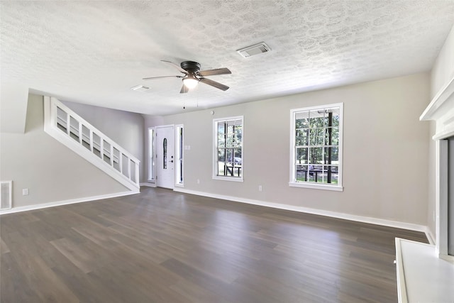 387 Hackberry Dr, Onalaska, TX 77360 - unfurnished living room featuring dark wood-type flooring, a textured ceiling, stairs, and ceiling fan
