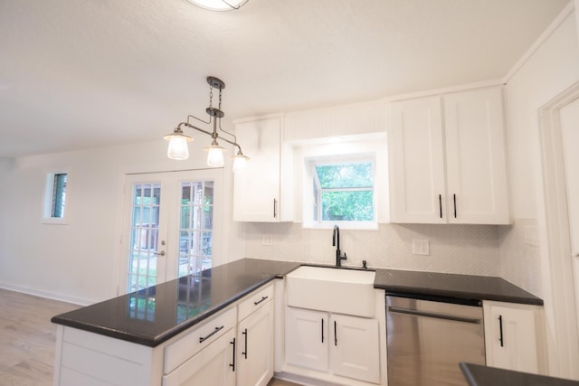 1025 Hathaway Ln, Marque, TX 77568 - kitchen with stainless steel dishwasher, dark countertops, a peninsula, tasteful backsplash, and white cabinets